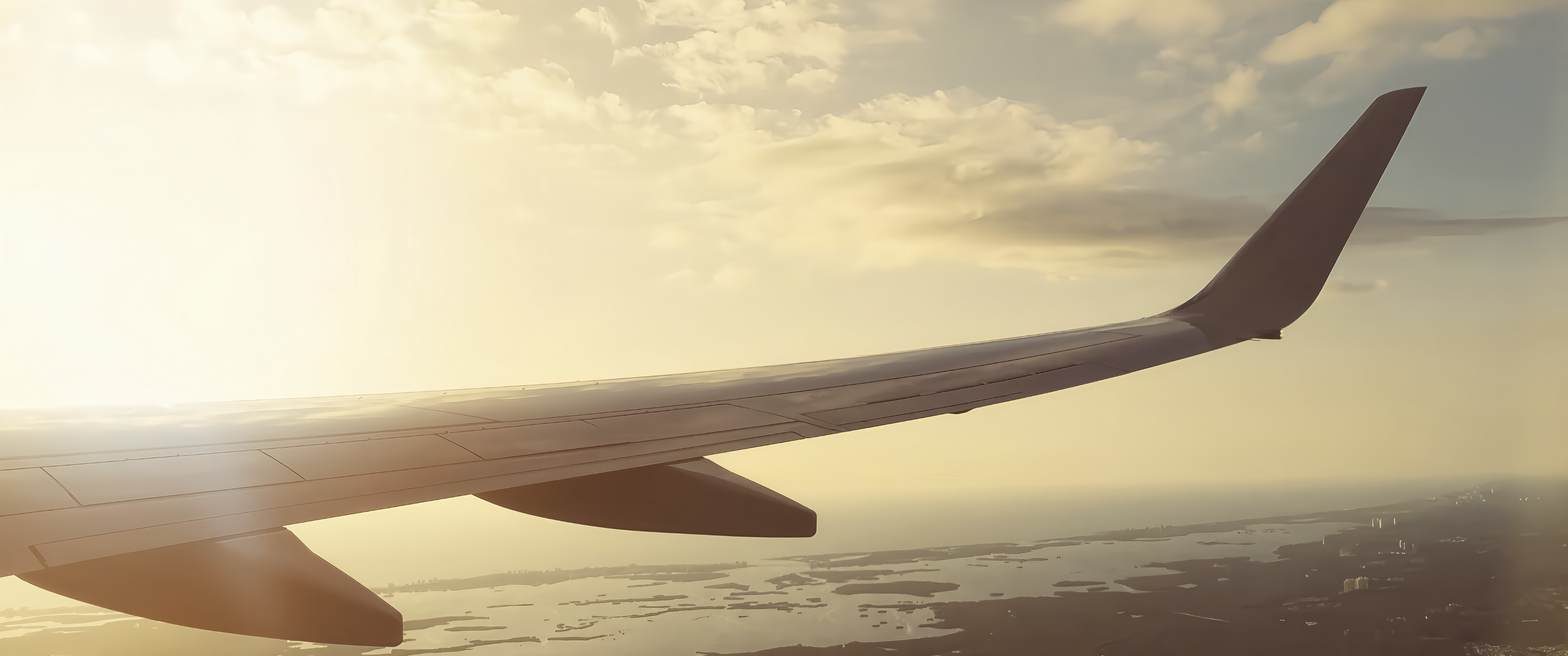 A wing of an aircraft at sunset.